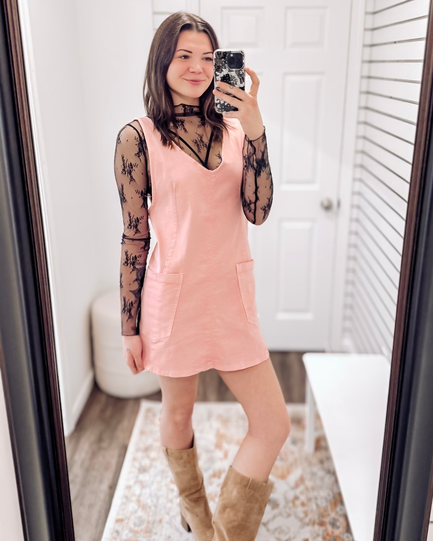 Sleeveless pink overall-style dress featuring a soft, washed fabric and relaxed fit. Designed with a flattering V-neckline, wide shoulder straps, and two front patch pockets for added charm and functionality. Hits above the knee with a slightly curved hem, making it perfect for layering over tanks or tees. A playful, easygoing piece for warm weather days.