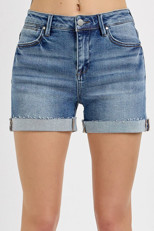 Medium-wash denim shorts featuring a high-rise fit with cuffed raw hems and subtle fading throughout. Designed with classic five-pocket styling and slight stretch for all-day comfort. These shorts hit that sweet spot between casual and polished—perfect for pairing with tanks, tees, or lightweight layers for a warm-weather go-to look.