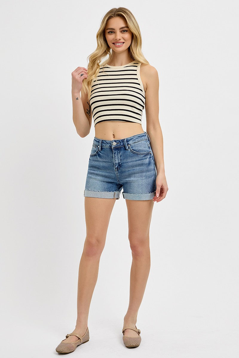 Medium-wash denim shorts featuring a high-rise fit with cuffed raw hems and subtle fading throughout. Designed with classic five-pocket styling and slight stretch for all-day comfort. These shorts hit that sweet spot between casual and polished—perfect for pairing with tanks, tees, or lightweight layers for a warm-weather go-to look.