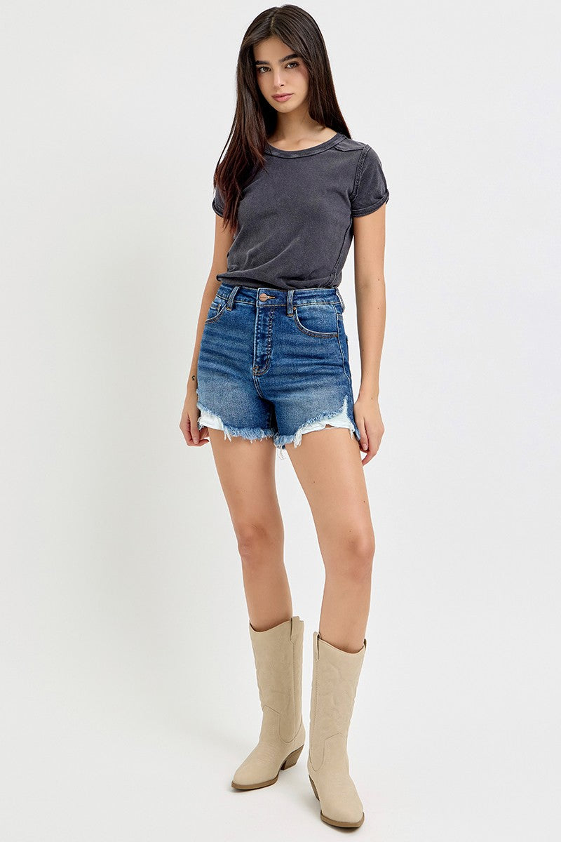 High-rise medium-wash denim shorts featuring a raw frayed hem with peekaboo white lining and light distressing along the edges. Designed with a classic five-pocket style and a flattering fit through the hips and thighs. These shorts are a laid-back summer staple—perfect for pairing with tanks, crop tops, or graphic tees for an effortlessly cool vibe