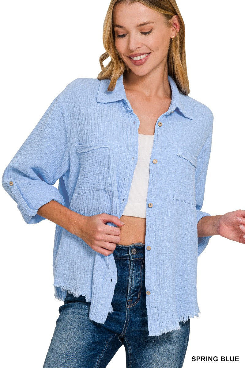 Lightweight and breezy button-down shirt in a soft, crinkled gauze fabric, featured in a fresh Spring Blue. Designed with dual chest pockets, raw-edge hem, and rolled long sleeves with button tabs. Slightly oversized fit for easy layering over tanks, tees, or swimsuits—perfect for casual days, lake life, or cool summer nights.