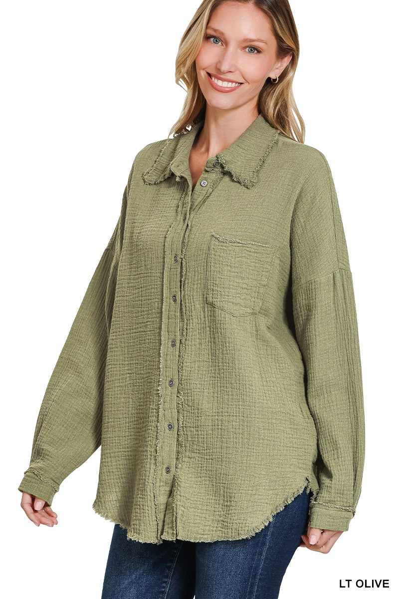 Women's oversized button-down shirt in light olive, crafted from a textured gauze fabric for a breathable and lived-in feel. Features raw-edge detailing on the collar and hem, front chest pocket, and functional button closures down the front. Drop shoulders and a relaxed fit make it ideal for layering over tanks or tees. A soft, casual essential for effortless cool-weather layering or breezy summer nights.
