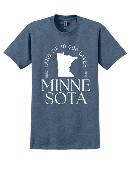 Heathered blue unisex t-shirt featuring a bold white graphic of the state of Minnesota, with the phrase “Land of 10,000 Lakes” encircling the silhouette. Below the graphic, elegant serif text reads “MINNESOTA” split across two lines. Includes subtle “ESTD 1858” details, nodding to the state's founding. Soft cotton-blend fabric with a classic fit—perfect for showing off Midwest pride in comfort and style.