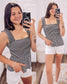 Woman wearing a black and white striped smocked peplum tank top with wide ruffled straps and a square neckline. The fitted smocked bodice creates a flattering silhouette, flaring into a flowy hem. Paired with light beige distressed denim shorts featuring frayed edges, this look is playful and breezy—perfect for sunny days, beach outings, or casual summer hangouts.