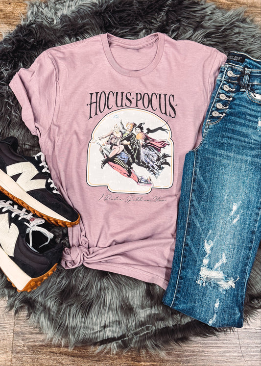 Pink t-shirt with graphic design, blue jeans, and sneakers on a fur rug.