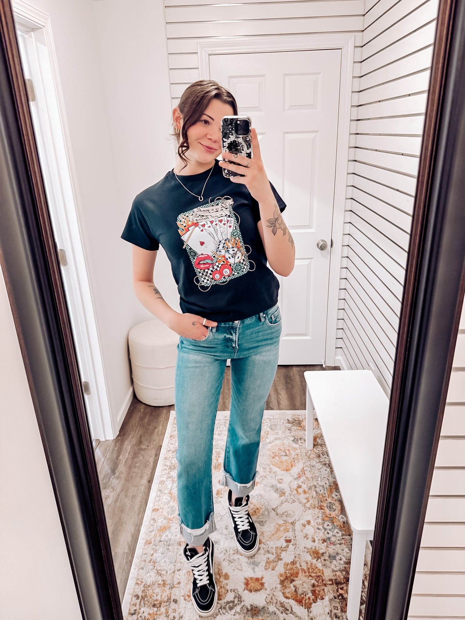 Black graphic tee featuring a bold vintage tattoo-inspired design with playing cards, flames, dice, pool balls, checkerboard accents, and red lips. Banner at the top reads “Life is a gamble, I’m just dealing.” Perfect for adding a little edge and attitude to your casual wardrobe—ideal for concerts, game nights, or days when you’re feeling a little wild.