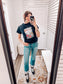Black graphic tee featuring a bold vintage tattoo-inspired design with playing cards, flames, dice, pool balls, checkerboard accents, and red lips. Banner at the top reads “Life is a gamble, I’m just dealing.” Perfect for adding a little edge and attitude to your casual wardrobe—ideal for concerts, game nights, or days when you’re feeling a little wild.