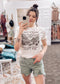 Cream-colored unisex graphic tee featuring a vintage-style desert landscape with cacti, mesas, and cloud-filled skies. The bold black text reads “Lord Willin’ And The Creek Don’t Rise,” giving major western vibes with a faith-filled twist. Styled here with sage green frayed shorts and a black wide-brim hat for an effortlessly cool, rustic look. Perfect for rodeo nights, Sunday coffee runs, or dusty backroad adventures.