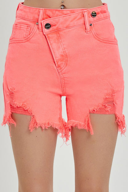 High-rise neon coral denim shorts with bold distressing and frayed hems. These eye-catching cutoffs feature a raw edge, angled hemline, and subtle peek-through front distressing for added flair. Designed with a crossover waistband and classic five-pocket construction. Perfect for adding a vibrant pop to your summer wardrobe—style with graphic tanks or breezy tees for a fun, playful look.