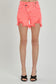 High-rise neon coral denim shorts with bold distressing and frayed hems. These eye-catching cutoffs feature a raw edge, angled hemline, and subtle peek-through front distressing for added flair. Designed with a crossover waistband and classic five-pocket construction. Perfect for adding a vibrant pop to your summer wardrobe—style with graphic tanks or breezy tees for a fun, playful look.