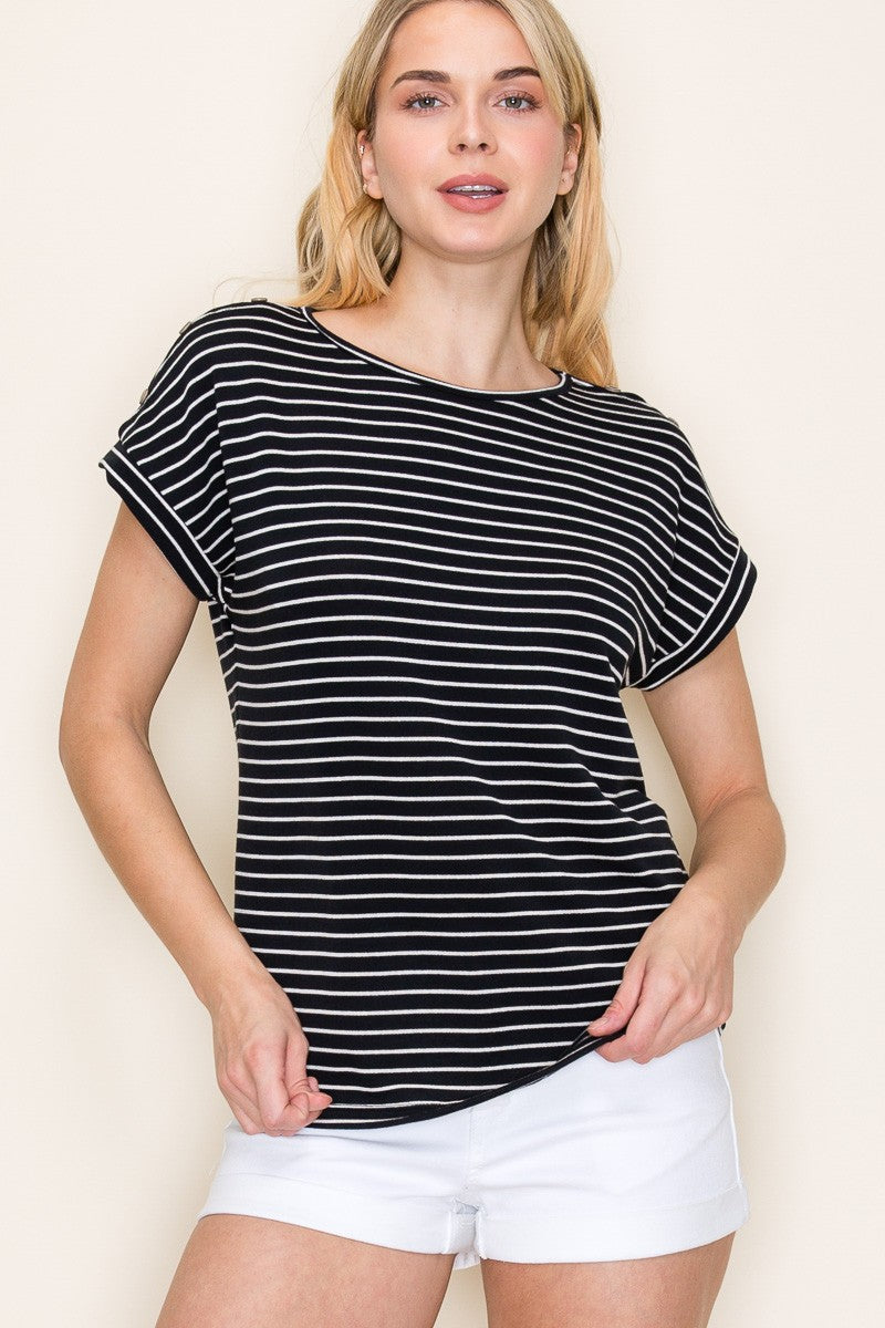 Woman wearing a black short-sleeve top with thin white horizontal stripes, a classic crew neckline, and rolled cuff sleeves with button accents. The top features a relaxed, drapey fit that pairs effortlessly with white cuffed shorts for a crisp, casual look. Perfect for everyday wear, this lightweight striped tee brings timeless style and comfort to your summer wardrobe.