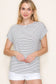 Woman wearing a white short-sleeve top with thin black horizontal stripes and rolled cuffs. The shirt features a relaxed, flowy fit with a crew neckline and button detail on the sleeves. Styled with white cuffed shorts, this effortless everyday tee is perfect for warm weather, offering a classic nautical-inspired look that’s both casual and polished.