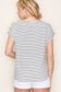 Woman wearing a white short-sleeve top with thin black horizontal stripes and rolled cuffs. The shirt features a relaxed, flowy fit with a crew neckline and button detail on the sleeves. Styled with white cuffed shorts, this effortless everyday tee is perfect for warm weather, offering a classic nautical-inspired look that’s both casual and polished.