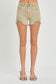 High-rise tan denim shorts with a perfectly lived-in look, featuring heavy distressing along the raw hem and side slits for extra edge. Classic five-pocket design with frayed detailing at the waistband and front pockets. These neutral cutoffs are easy to pair with any summer tank or graphic tee, making them a go-to for lake days, festivals, or backyard hangs.