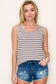 Woman wearing a casual sleeveless tank top with horizontal taupe and white stripes. The top features a scoop neckline and a relaxed, slightly flared silhouette that offers a breezy, comfortable fit. Styled with distressed dark-wash denim shorts, this easygoing look is perfect for everyday wear, beach days, or layering under summer cardigans and jackets.