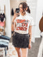 Beige graphic tee featuring a bold red "Tears of a Cowboy" slogan layered over a black-and-white rodeo newspaper print. Accents include dice, a horseshoe, and distressed lettering for an edgy Western-meets-streetwear vibe. Perfect for rodeo rebels, heartbreak cowgirls, or anyone living on the wild side of the saddle.