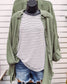 Women's oversized button-down shirt in light olive, crafted from a textured gauze fabric for a breathable and lived-in feel. Features raw-edge detailing on the collar and hem, front chest pocket, and functional button closures down the front. Drop shoulders and a relaxed fit make it ideal for layering over tanks or tees. A soft, casual essential for effortless cool-weather layering or breezy summer nights.