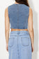 Light wash denim vest top featuring a tailored V-neckline, angled hemline, and asymmetrical button-down front. This sleeveless piece adds a vintage-meets-modern vibe to any outfit and pairs perfectly with high-rise jeans or shorts for an edgy, casual-cool look.