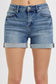 Medium-wash denim shorts featuring a high-rise fit with cuffed raw hems and subtle fading throughout. Designed with classic five-pocket styling and slight stretch for all-day comfort. These shorts hit that sweet spot between casual and polished—perfect for pairing with tanks, tees, or lightweight layers for a warm-weather go-to look.