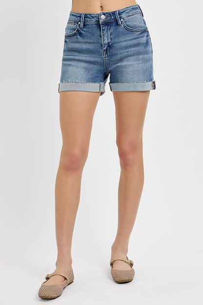 Medium-wash denim shorts featuring a high-rise fit with cuffed raw hems and subtle fading throughout. Designed with classic five-pocket styling and slight stretch for all-day comfort. These shorts hit that sweet spot between casual and polished—perfect for pairing with tanks, tees, or lightweight layers for a warm-weather go-to look.
