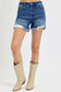 High-rise medium-wash denim shorts featuring a raw frayed hem with peekaboo white lining and light distressing along the edges. Designed with a classic five-pocket style and a flattering fit through the hips and thighs. These shorts are a laid-back summer staple—perfect for pairing with tanks, crop tops, or graphic tees for an effortlessly cool vibe