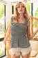 Woman wearing a black and white striped smocked peplum tank top with wide ruffled straps and a square neckline. The fitted smocked bodice creates a flattering silhouette, flaring into a flowy hem. Paired with light beige distressed denim shorts featuring frayed edges, this look is playful and breezy—perfect for sunny days, beach outings, or casual summer hangouts.