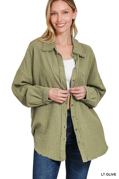 Women's oversized button-down shirt in light olive, crafted from a textured gauze fabric for a breathable and lived-in feel. Features raw-edge detailing on the collar and hem, front chest pocket, and functional button closures down the front. Drop shoulders and a relaxed fit make it ideal for layering over tanks or tees. A soft, casual essential for effortless cool-weather layering or breezy summer nights.