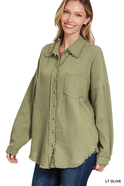 Women's oversized button-down shirt in light olive, crafted from a textured gauze fabric for a breathable and lived-in feel. Features raw-edge detailing on the collar and hem, front chest pocket, and functional button closures down the front. Drop shoulders and a relaxed fit make it ideal for layering over tanks or tees. A soft, casual essential for effortless cool-weather layering or breezy summer nights.